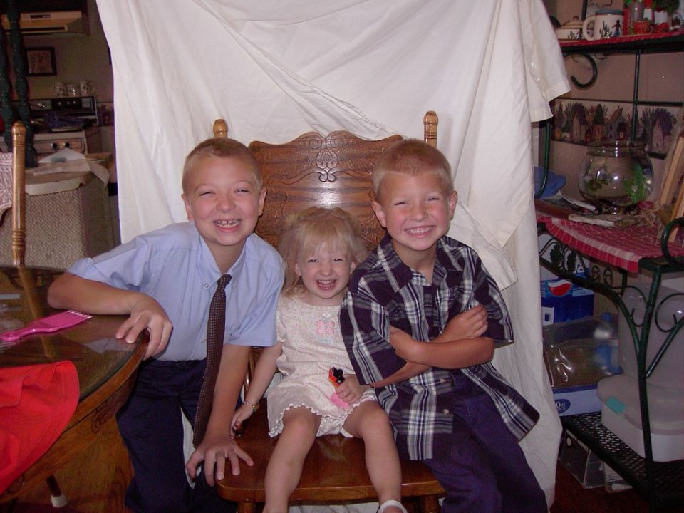 Three children smiling for a photo indoors