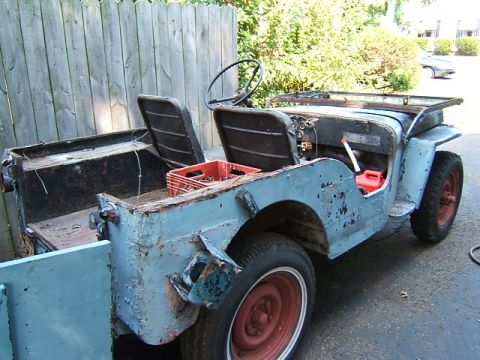 1950 Jeep CJ5 - This 1949 Jeep CJ-3A is seen from the rear three-quarter angle, showing its light blue paint and a red crate in the cargo bed.