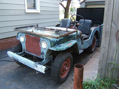 1950 Jeep CJ5 - This Jeep CJ-3A shows significant wear and tear, with its hood up and paint faded.