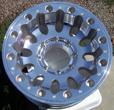 1995 Ford Bronco - A polished chrome wheel is shown, an intricate spoke design and numerous bolt holes.
