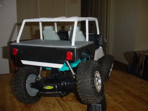 1988 Ford Bronco - This remote control vehicle is displayed indoors on a wooden floor, elevated on a stand.