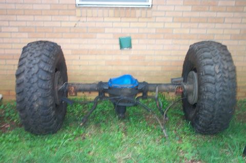 1987 Ford Bronco - Rear axle assembly with oversized tires and a blue differential cover, likely for an off-road vehicle.