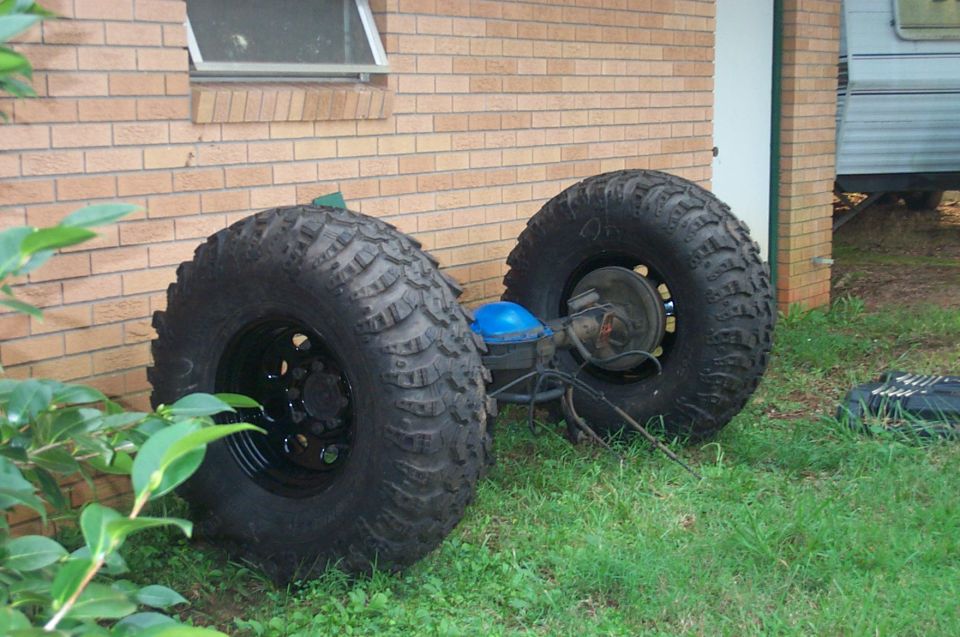 Rear axle with large off-road tires and blue differential cover
