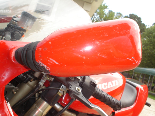 Close-up of red Ducati motorcycle bodywork with grip, brake lever and DUCATI logo