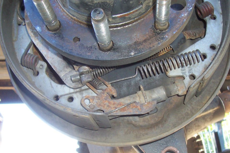 Disassembled drum brake assembly showing shoes springs and hardware
