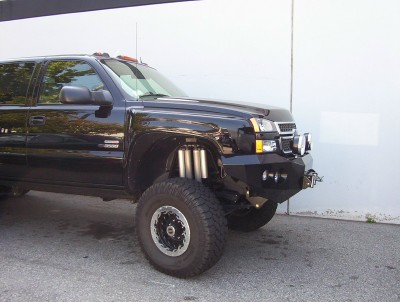 1995 Ford Bronco - This modified black truck features a heavy-duty custom bumper and an exposed suspension system, suggesting off-road capabilities.
