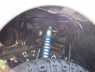1995 Ford Bronco - Close-up view of a vehicle's suspension system, showing a shock absorber and tire.