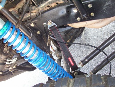 1995 Ford Bronco - Close-up view of a vehicle's suspension system, highlighting a blue coilover shock absorber.