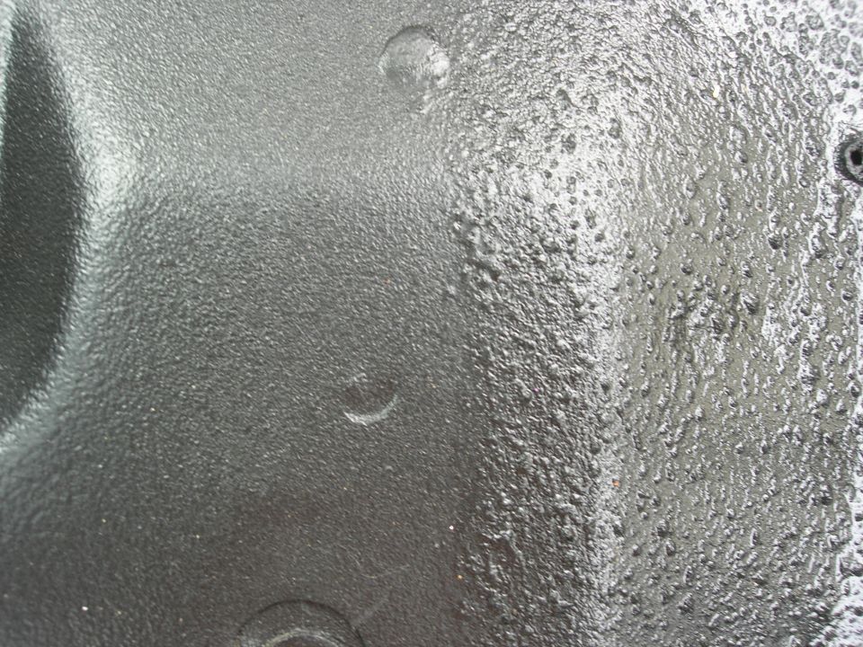 Close-up of black textured bedliner-type coating on a vehicle panel