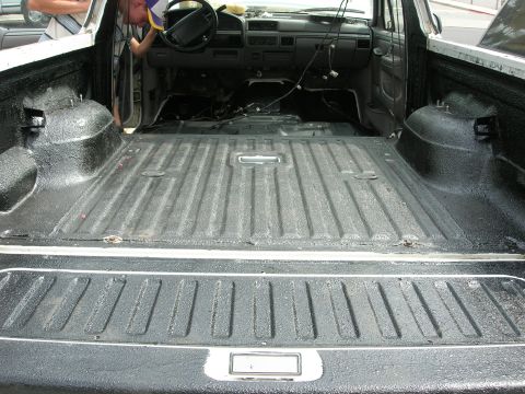 1994 Ford Bronco - The interior and bed of a pickup truck are shown, a Herculiner coating on the bed.