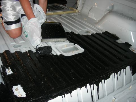 1994 Ford Bronco - Applying protective coating to the ribbed surface of a truck bed interior.