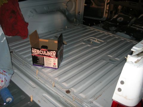 1994 Ford Bronco - Herculiner truck bed liner kit box and roller sit inside a bare truck bed.