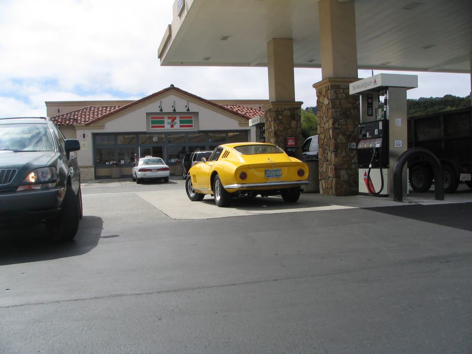 Yellow 1967 Ferrari 275 GTB/4 parked at a gas station