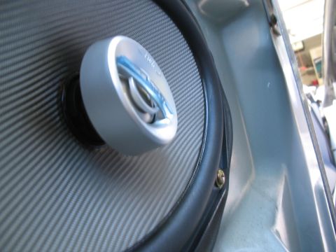 1993 Ford Probe - Close-up of a car door speaker, a carbon fiber cone and a silver tweeter with blue accents.