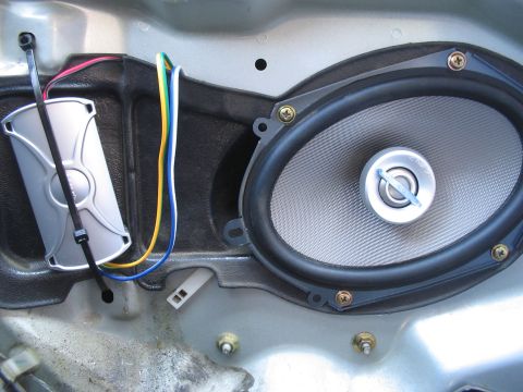 1993 Ford Probe - Close-up view of a car's interior door panel revealing the speaker assembly and associated electrical connections.
