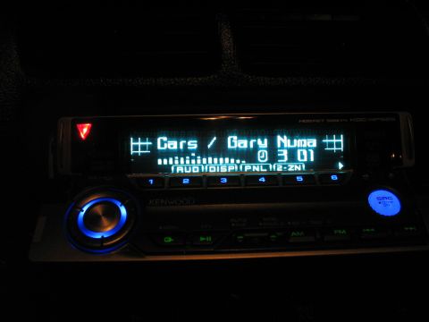 1993 Ford Probe - A Kenwood car stereo displays song information and track time in a dimly lit interior.