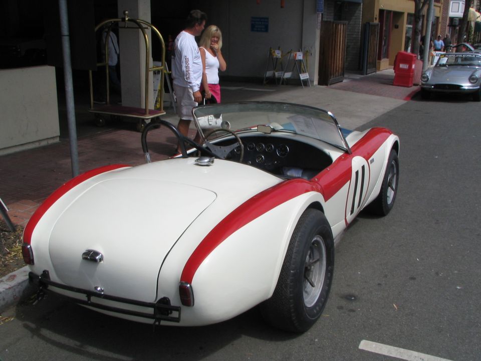 White and red convertible sports car with racing stripes and number 11