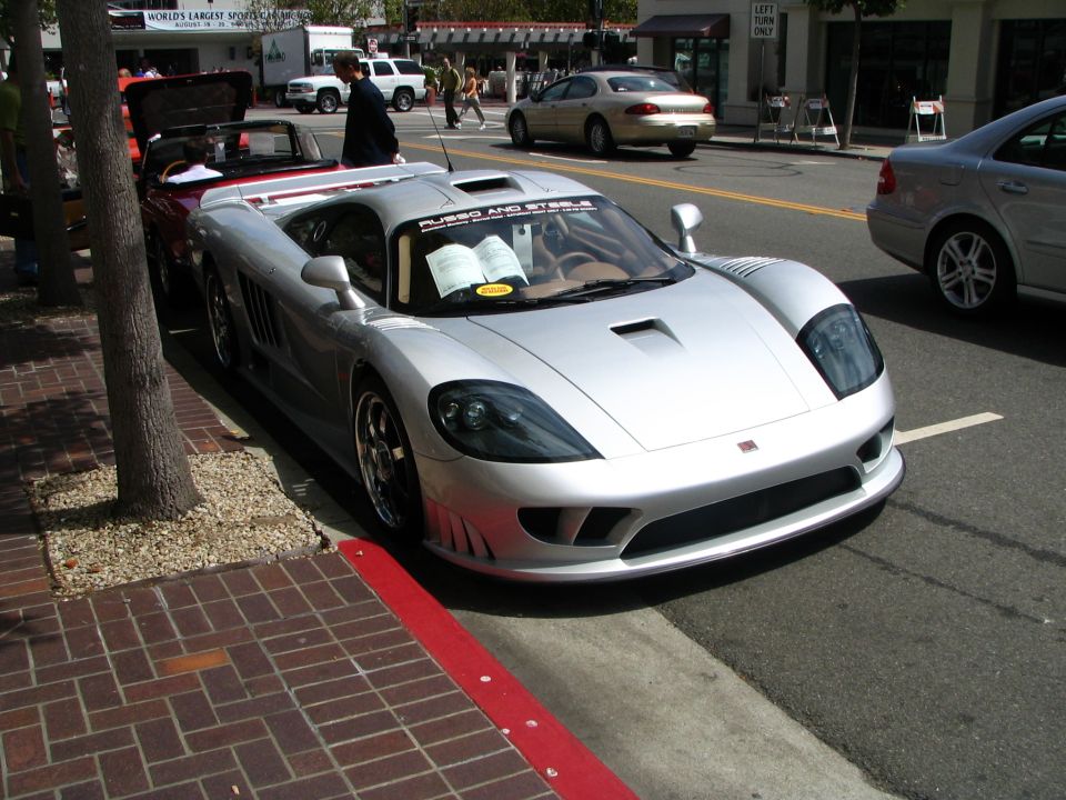 Silver Saleen S7 sports car parked on street, another convertible in background