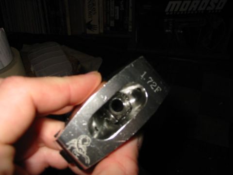 1985 Ford LTD Crown Victoria - A hand holds a metal engine component with visible markings and a scorpion emblem.