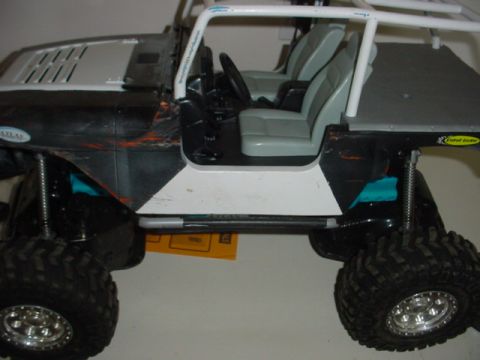 1988 Ford Bronco - This RC crawler vehicle has a roll cage and gray interior seats.