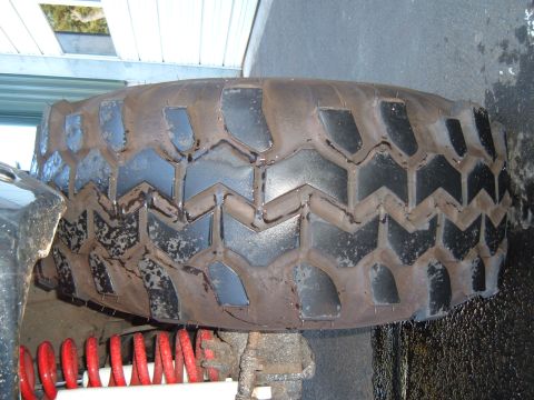 1989 Ford Bronco - A close-up view of a tire and suspension component, with visible text from Supermotors.net.