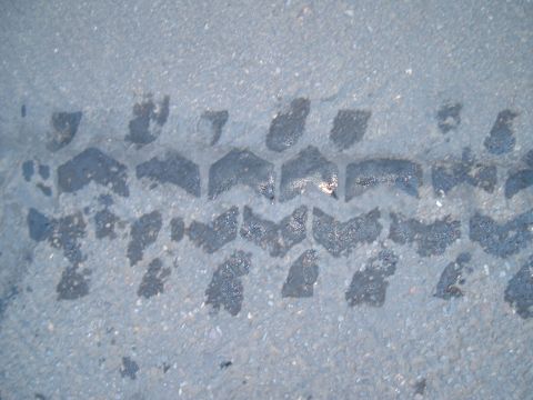 1989 Ford Bronco - Tire tread impression visible on the road surface.