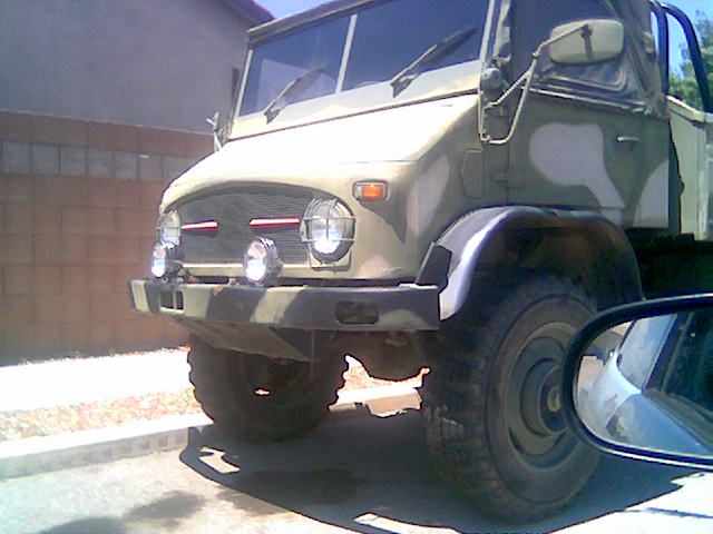 Camo Mercedes Unimog truck front three-quarter view with off-road tires