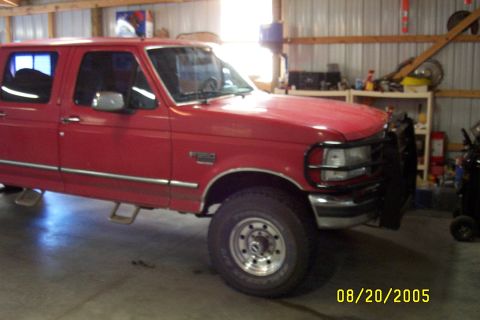 1995 Ford F-350 - This red 1995 Ford F-350 crew cab pickup truck is shown from a 3/4 front angle inside a garage.