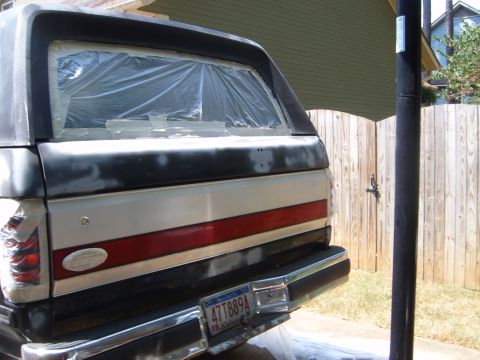 1988 Ford Bronco - Rear view of a 1988 Ford Bronco undergoing paint preparation, showing the taped-off rear window and license plate.