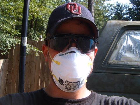1988 Ford Bronco - A person wearing a mask and safety glasses stands in front of a vehicle that appears to be undergoing paint preparation.