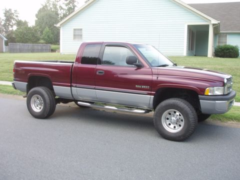 1995 Ford Bronco - This maroon and silver Dodge Ram 2500 pickup truck is shown from the side.