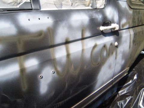 1988 Ford Bronco - Spray paint text 'tutt.com' is visible on the side door of a vehicle undergoing painting.