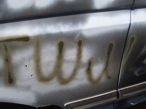 1988 Ford Bronco - Unidentified spray-painted text is visible on the side of a vehicle, obscuring any identifying features.