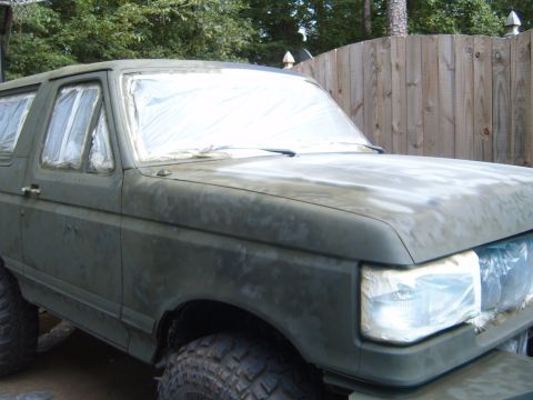 1988 Ford Bronco - This Ford Bronco is covered in masking tape and primer, indicating it is being prepped for a new paint job.