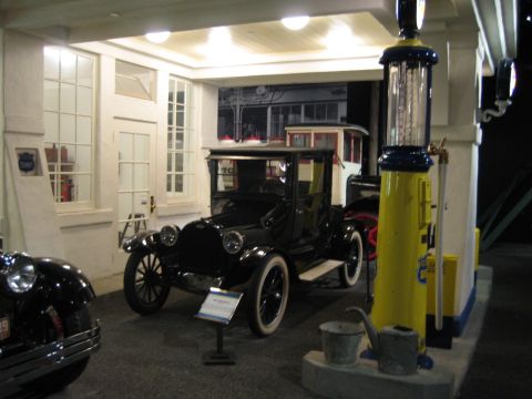 1968 Ford Mustang - A black vintage automobile is displayed next to a classic gas pump, evoking a bygone era of automotive service.