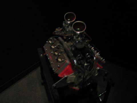 1968 Ford Mustang - A V8 engine with dual carburetors is displayed, red valve covers and chrome accents.