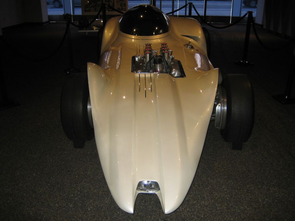 Cream streamliner with exposed engine and black bubble canopy, front view