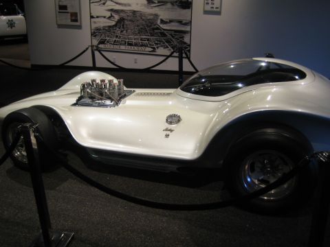 1968 Ford Mustang - A custom-built dragster with a prominent V8 engine is displayed indoors, likely in a museum setting.