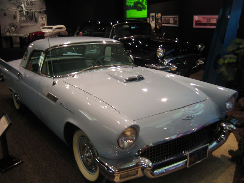 Light blue 1955-1957 Ford Thunderbird, 3q-front view. Another black car is behind it