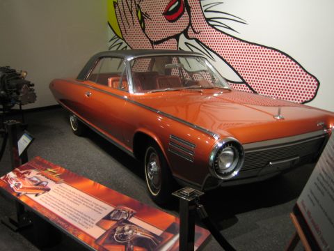 1968 Ford Mustang - This vintage coupe is displayed indoors, with a colorful pop art mural on the wall behind it.