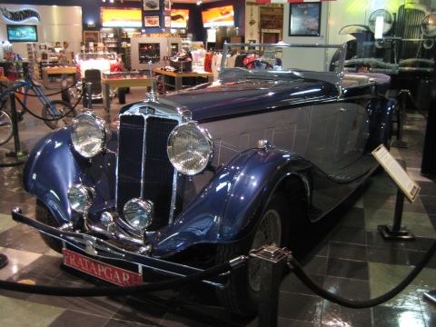 1968 Ford Mustang - A vintage convertible is displayed indoors, possibly in a museum or showroom, with ropes guiding visitors.