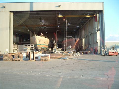 1995 Mercury Grand Marquis - Boats being built inside a large industrial hangar with a crane visible.
