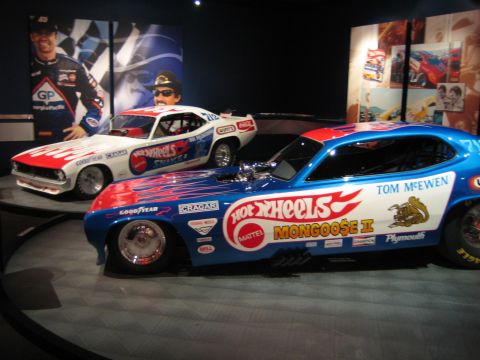 1968 Ford Mustang - Two vintage drag racing cars, one blue and one white, are displayed with "Hot Wheels" branding and driver names.