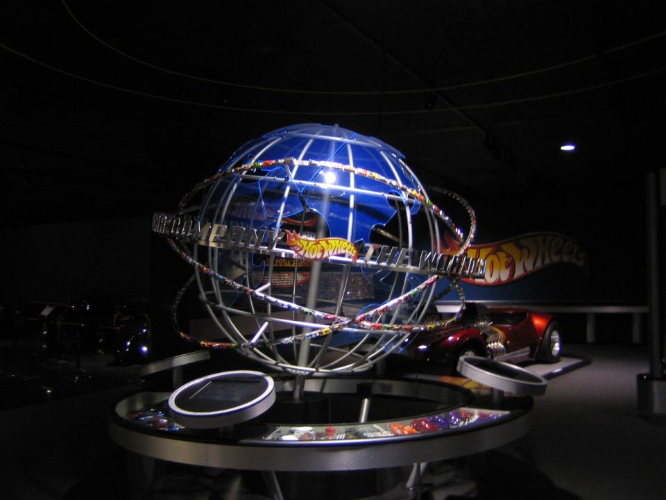 Hot Wheels display with a globe and a red sports car