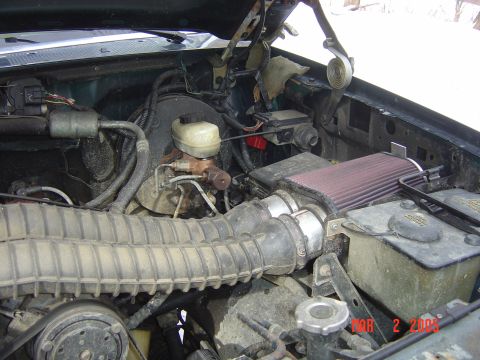 1993 Ford Bronco - The engine bay shows an aftermarket air intake system and various engine components.