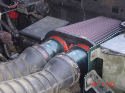 1993 Ford Bronco - Close-up of an engine's air intake system, showing the filter and tubing.