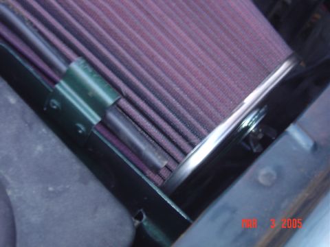 1993 Ford Bronco - A close-up view of a vehicle's air filter element, showing its pleated purple media and surrounding components.