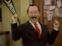 1995 Ford Bronco - Man in suit and tie cheers while holding a pennant.
