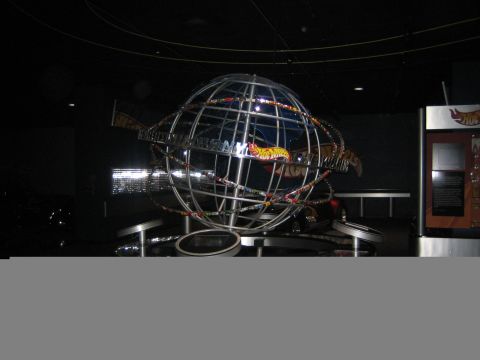 1968 Ford Mustang - A large globe sculpture Hot Wheels cars is displayed indoors, with informational panels nearby.