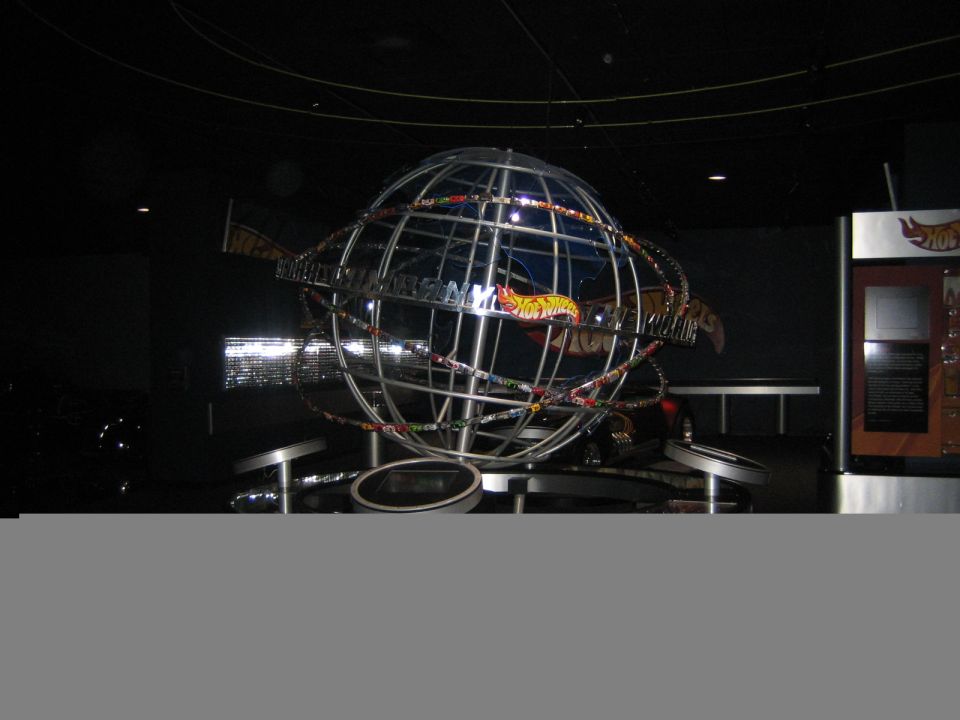 Globe structure with Hot Wheels cars on display, some text visible